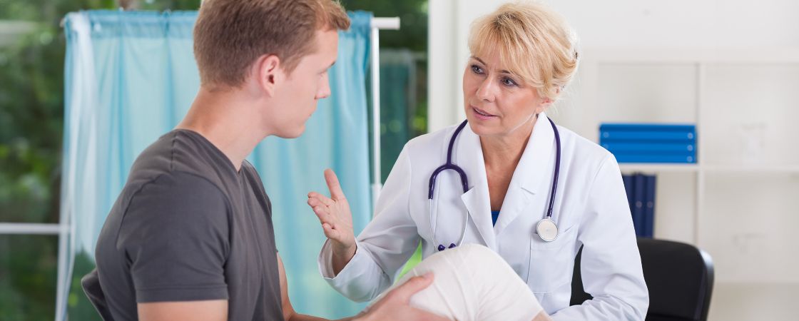 Doctor speaking to patient with wound on knee