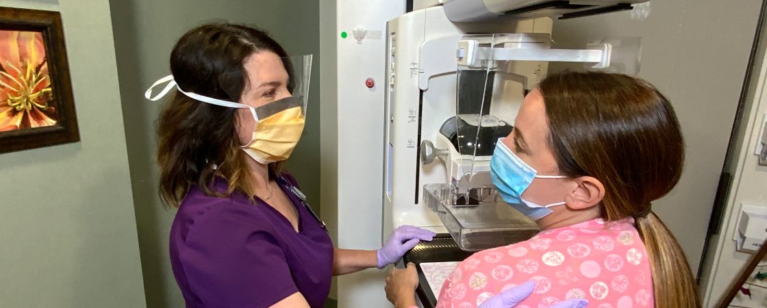 Nurse and patient next to mammogram machine