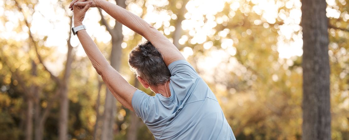 Older woman stretching outside