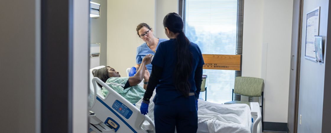 Nurses caring for patient in hospital bed