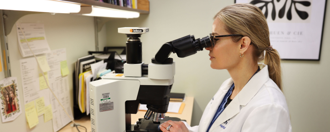 Doctor looking through microscope