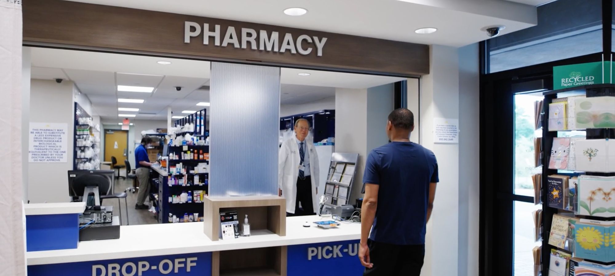 Pharmacist talking to person at pick-up window