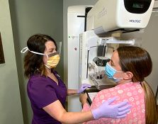 Nurse and patient next to mammogram machine