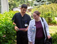 Two nurses looking at a folder while walking outside