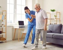 Nurse helping elderly patient walk