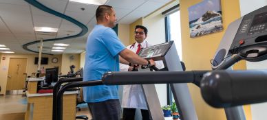 Doctor assisting patient on treadmill