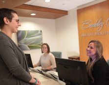 Patient speaking to front desk employees