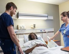 Nurses talking with patient in hospital bed