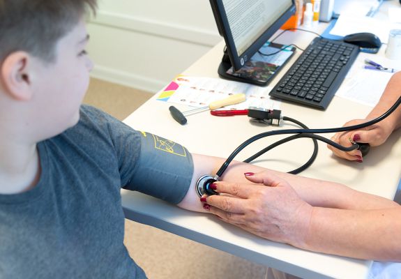 Nurse using a stethoscope to examine the patient