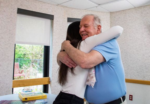 Two people smiling and hugging