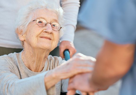 Elderly patient with hand on nurse's hand