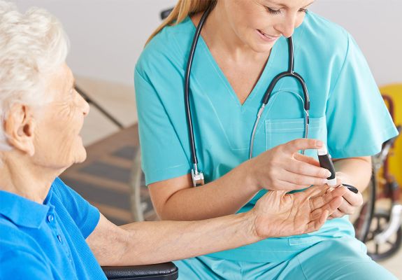 Nurse pricking finger of older woman