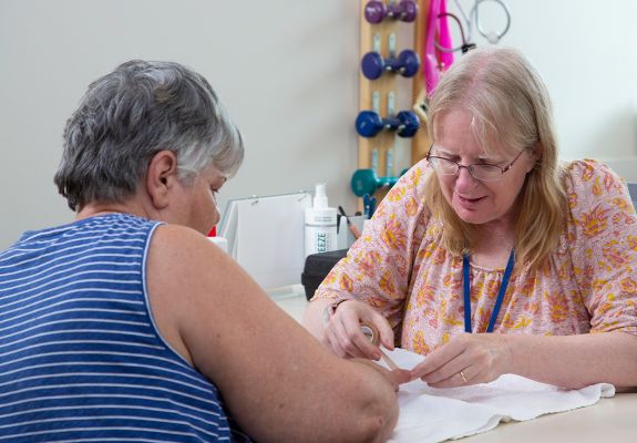 Woman wrapping patient's finger with a bandage