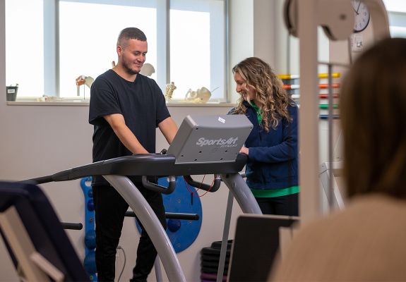 Bristol Health employee helping patient with walking strength