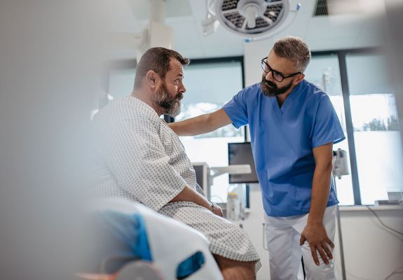 Man comforting patient in hospital