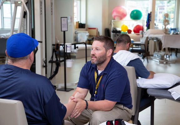 Rehab center with employee and patient speaking