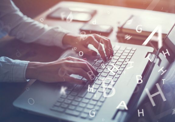 Person typing on laptop keyboard