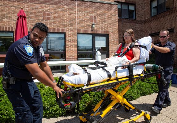 Patient being rolled in stretcher by EMT