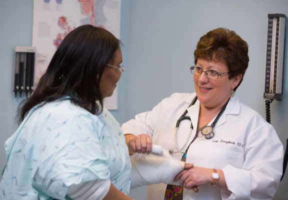 Doctor wrapping cast on patient