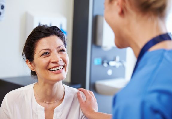 Nurse comforting the patient placing a hand on their shoulder