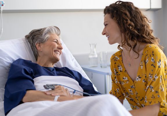 Volunteer speaking to patient in hospital bed