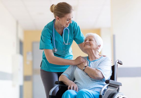 Nurse comforting patient in a wheel chair