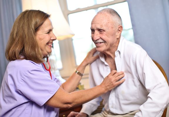 Nurse and older male patient laughing together