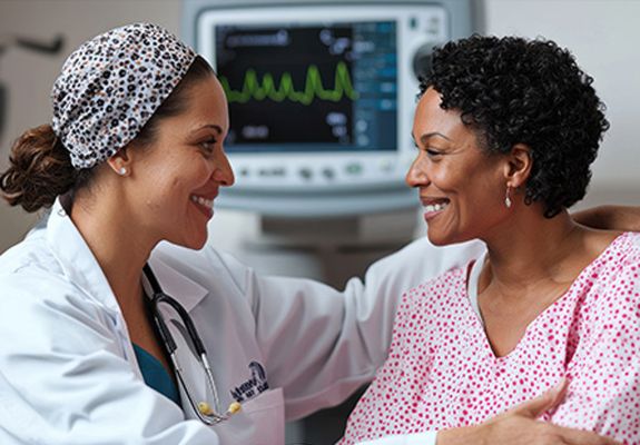 Doctor speaking to woman in front of mammogram machine