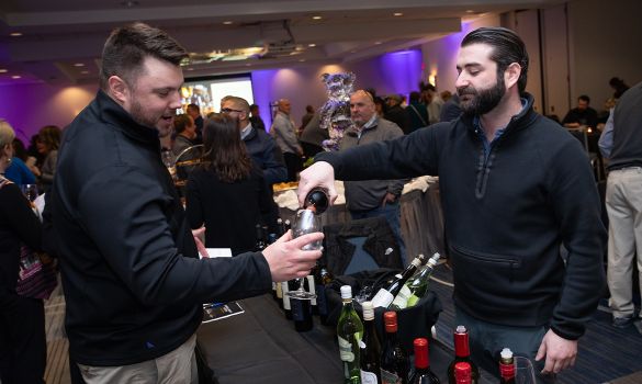 Bartender serving man wine at event