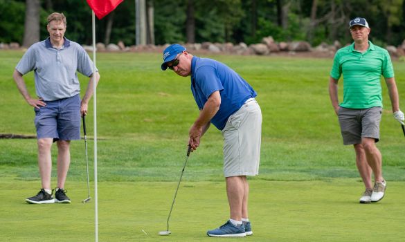 Three men playing golf